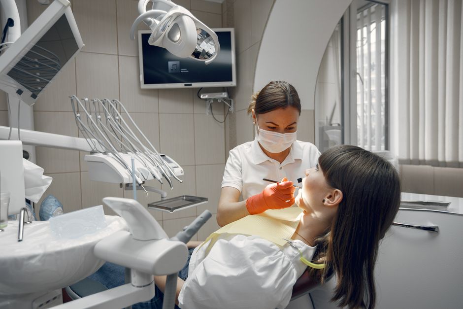 Dentist treating a smiling patient in a modern dental chair