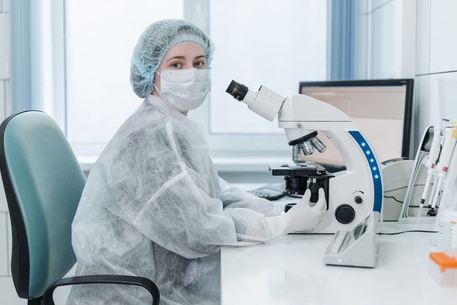 Laboratory technician examining samples with a microscope